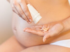 Mujer embarazada tomando ácido fólico Mujer embarazada tomando ácido fólico