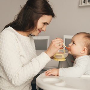 mamá dando de comer a bebé diferencia entre el cereal infantil y el cereal familiar