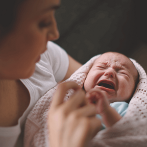 Woman holding a crying baby, trying to soothe him. Woman holding a crying baby, trying to soothe him.