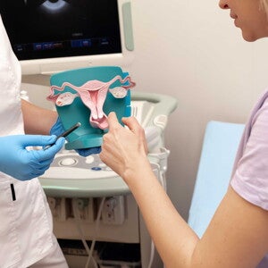Médico con modelo anatómico de útero Conoce las formas de ayudar a tu cuerpo a sentirse mejor