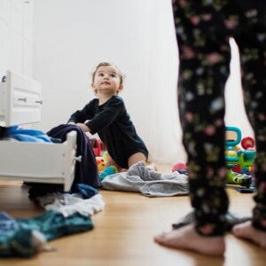 young child looking through clothes drawers