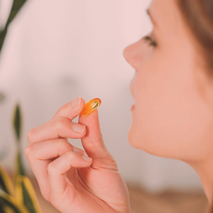 Side view of a woman taking a supplement Side view of a woman taking a supplement