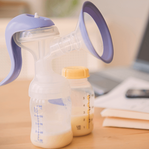 Partially filled breastmilk pump standing next to an also partially fill breastmilk bottle. Partially filled breastmilk pump standing next to an also partially fill breastmilk bottle.