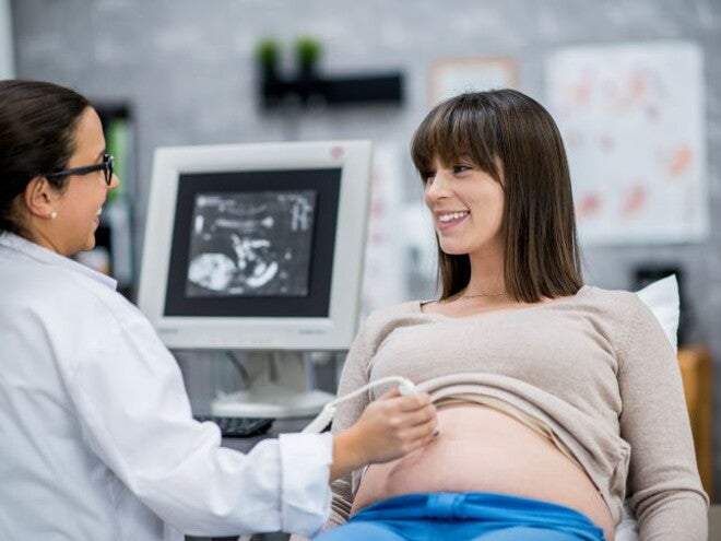Calendario de visitas al doctor Mujer en consultorio tomando una cita prenatal