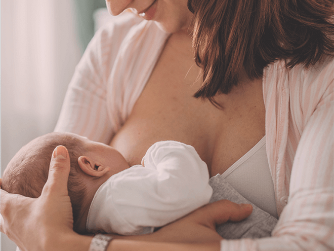 Smiling woman breastfeeding her baby Smiling woman breastfeeding her baby