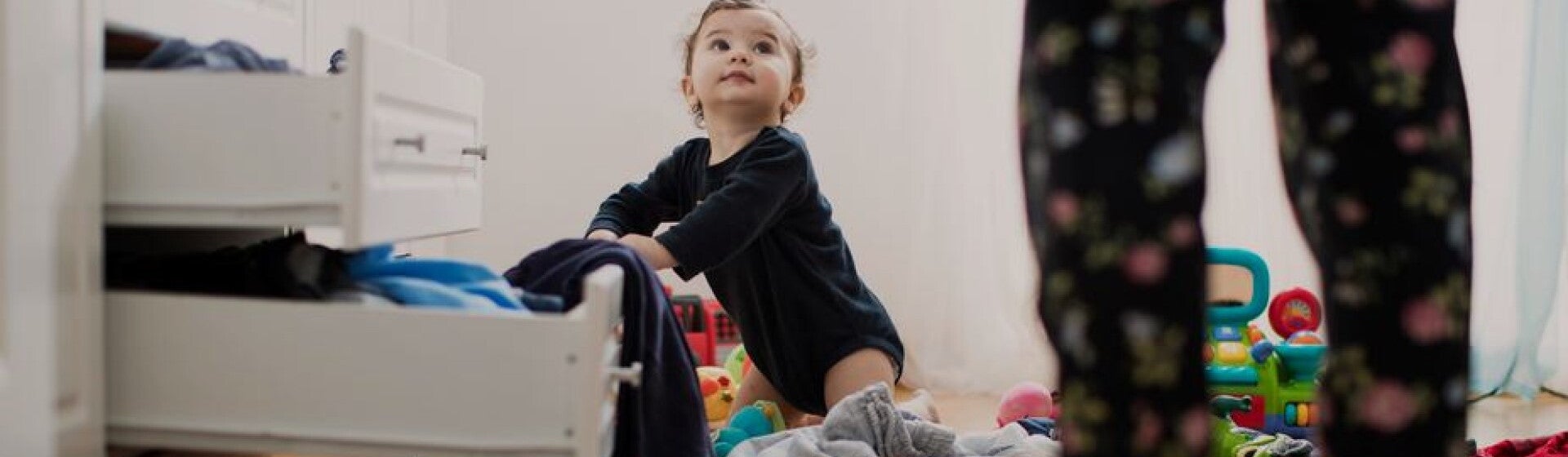 young child looking through clothes drawers young child looking through clothes drawers