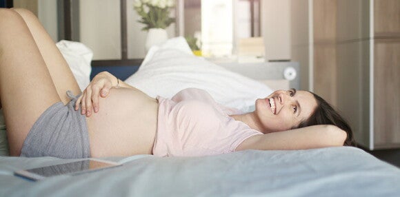 El tamaño y color del pezón son algunos de los cambios Mujer embarazada recostada en la cama