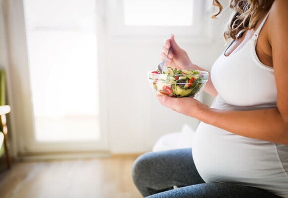 Joven embarazada consume alimentos ricos en hierro Joven embarazada consume alimentos ricos en hierro